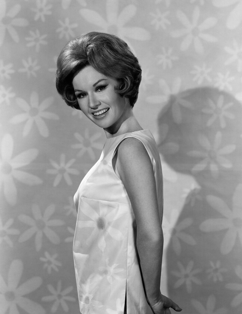 Patricia Crowley posing in a floral shift dress to promote Please Don't Eat the Daisies