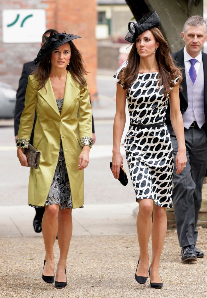 Kate Middleton in a black and white dress with Pippa Middleton in a green coat