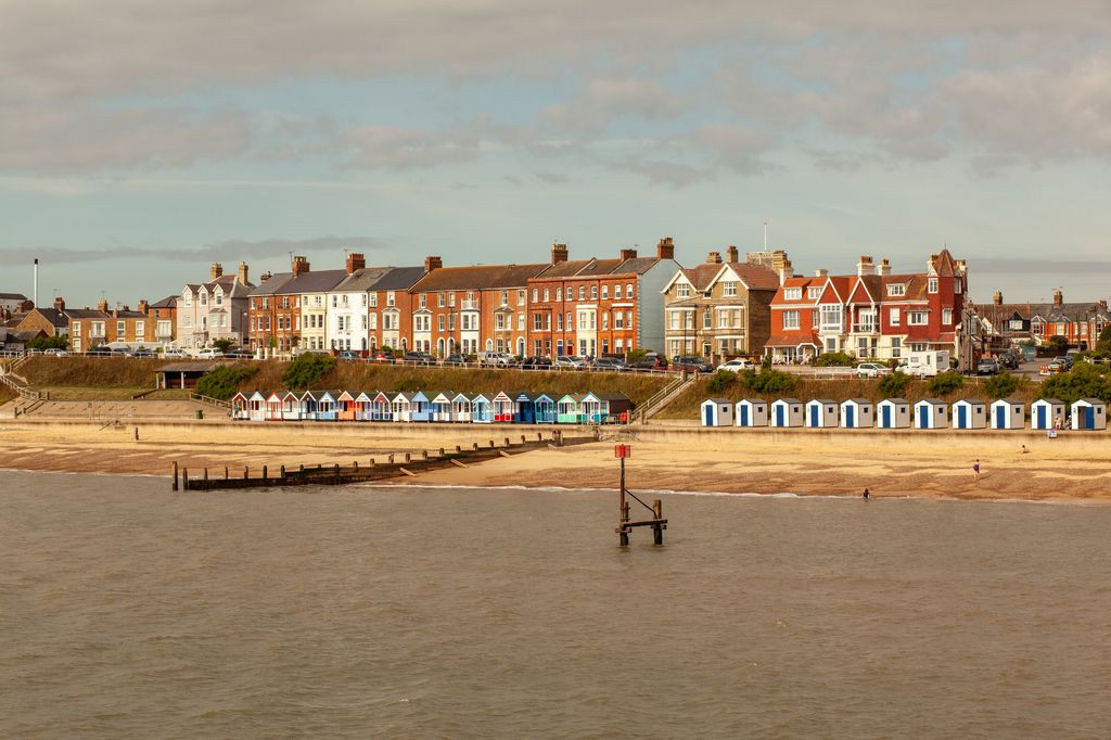Colourful beach huts and English houses line the coast of the East of England.