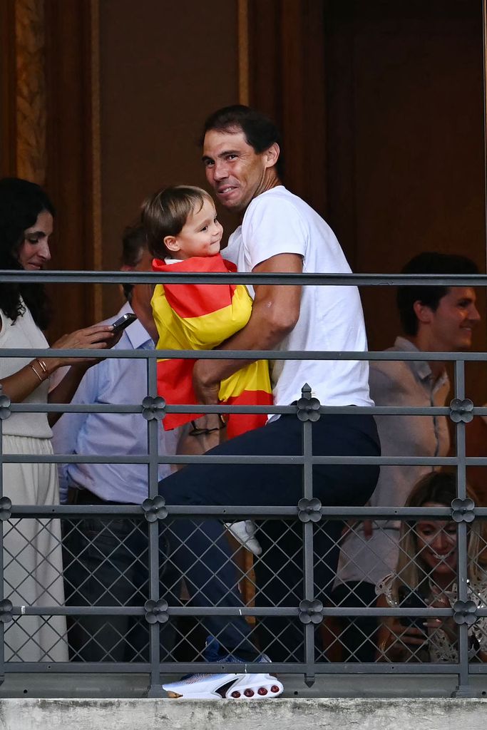 Rafael Nadal carrying a baby draped in the Spanish national flag