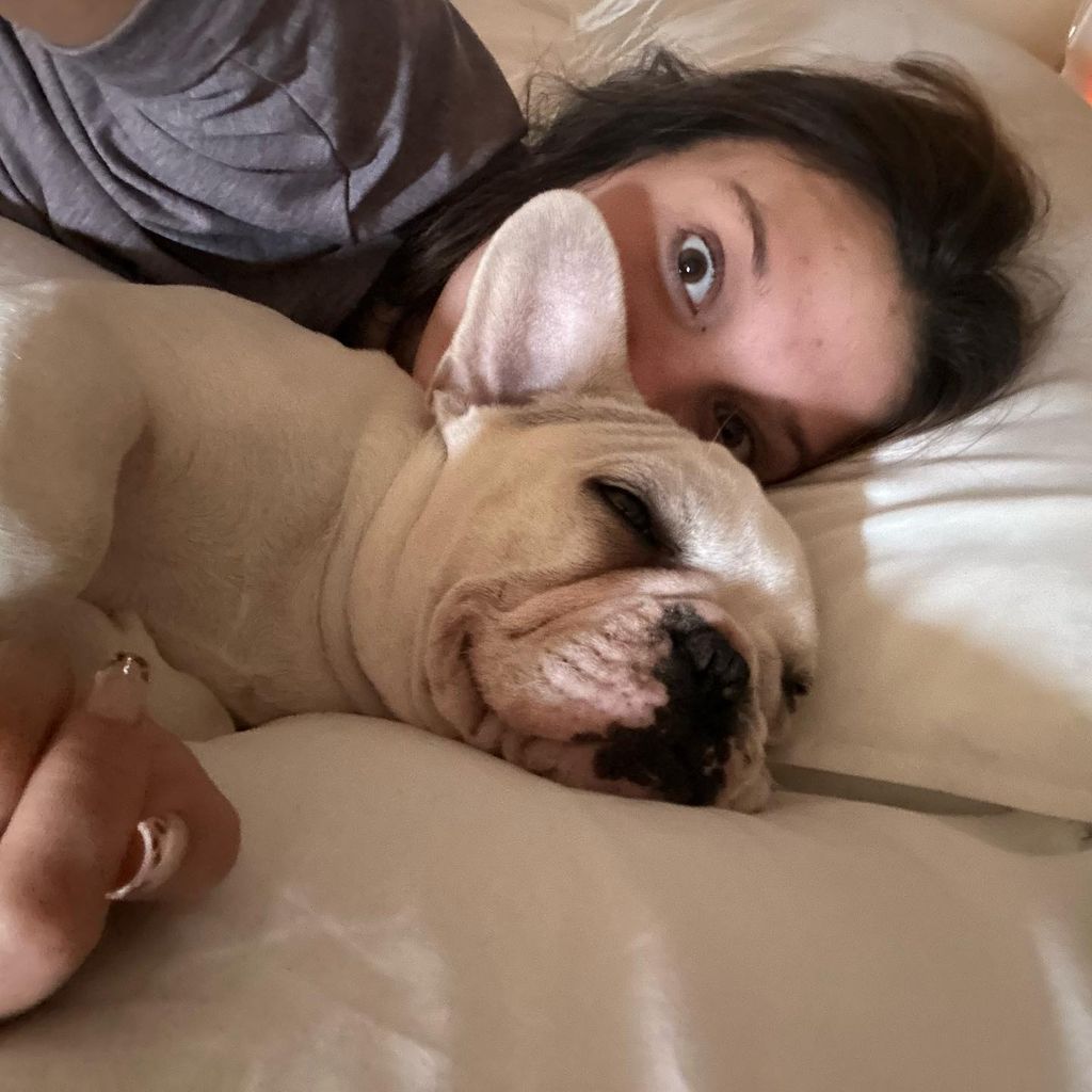 Millie Bobby Brown with a dog in her bed