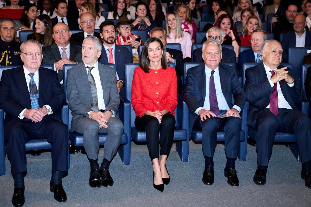 Queen Letizia in auditorium in red jacket 