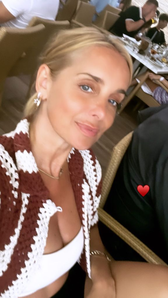 Louise Redknapp smiling at the camera with her hair tied back