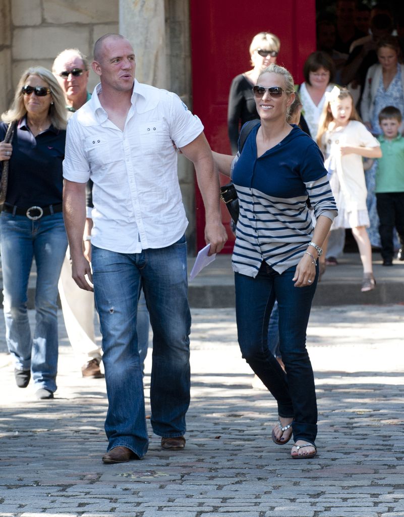 Zara Tindall with a blue pedicure holding Mike Tindall's arm