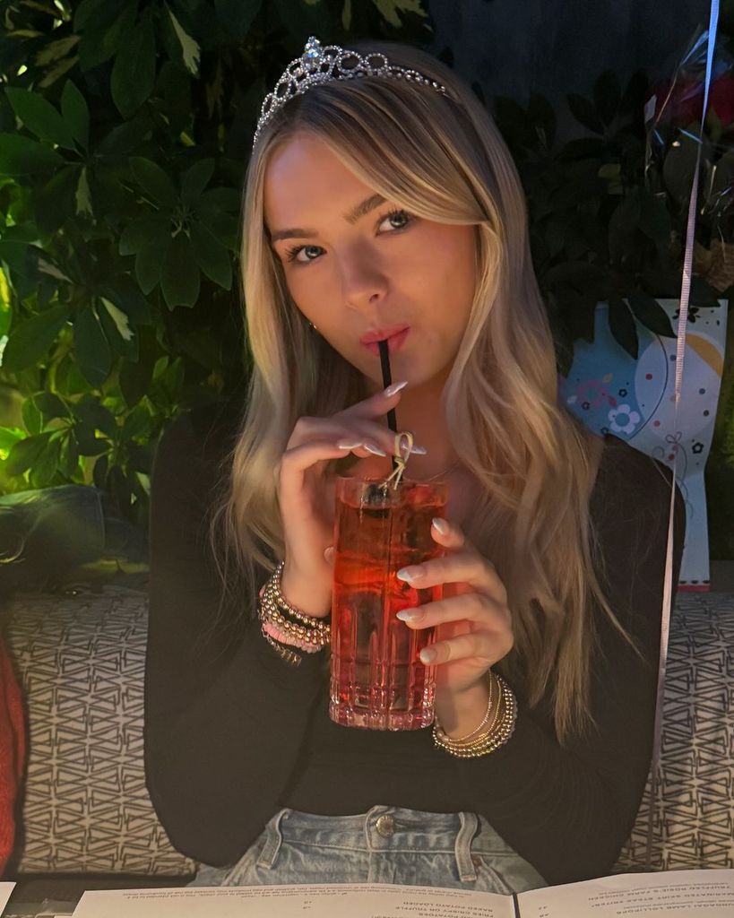 Jennie Garth's daughter Fiona poses with a straw in her mouth wearing a tiara