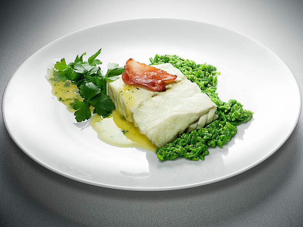 Fresh cod with sauce and green beans on white plate