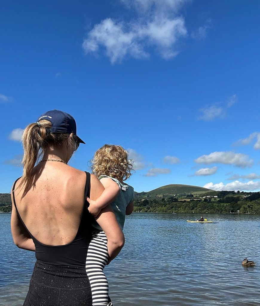 Helen Skelton posing in swimsuit on lake while holding daughter Elsie
