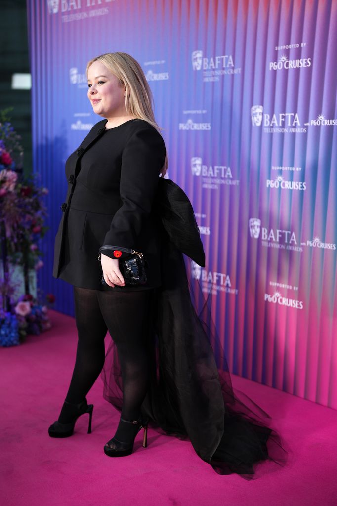 Another angle of Nicola Coughlan's incredible outfit - you can see here the giant mesh bow at the back of her outfit, and her skyscraper black heels