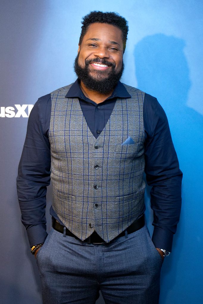 Malcom-Jamal Warner smiling in a suit
