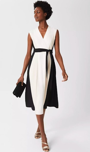 Hobbs model wearing a white dress with black belt