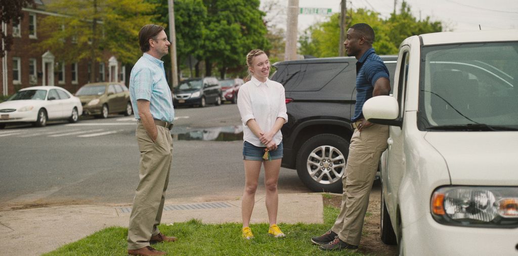 3 people stand by a car