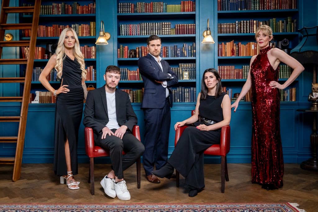 Five people in a room with blue bookshelves and a ladder