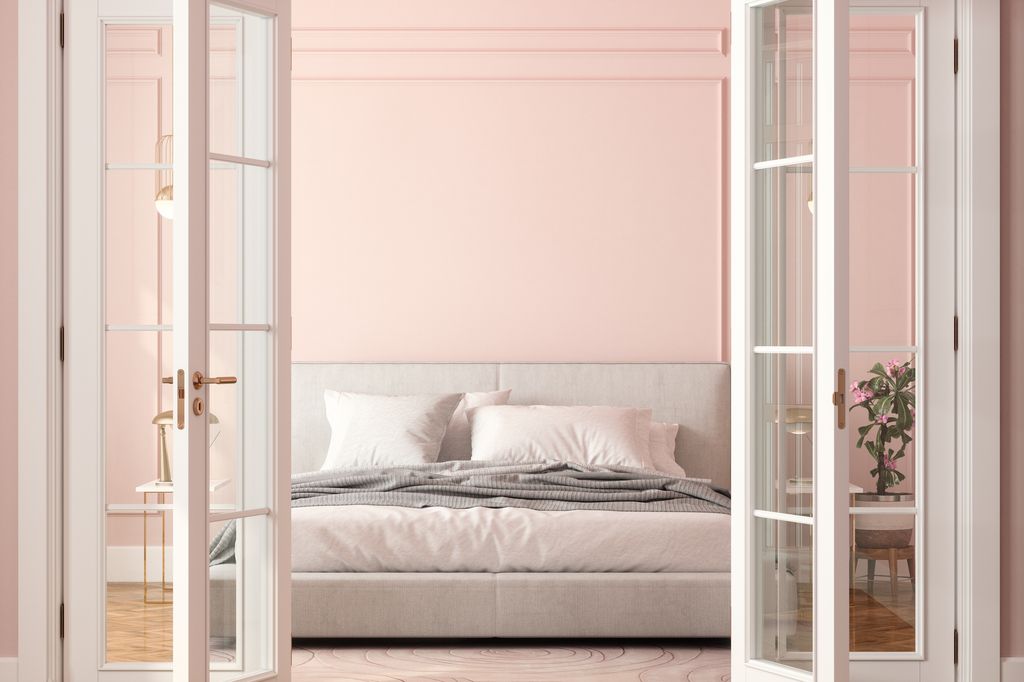 Front View Of Bedroom Entrance With Open Door, Bed And Pink Wall Background