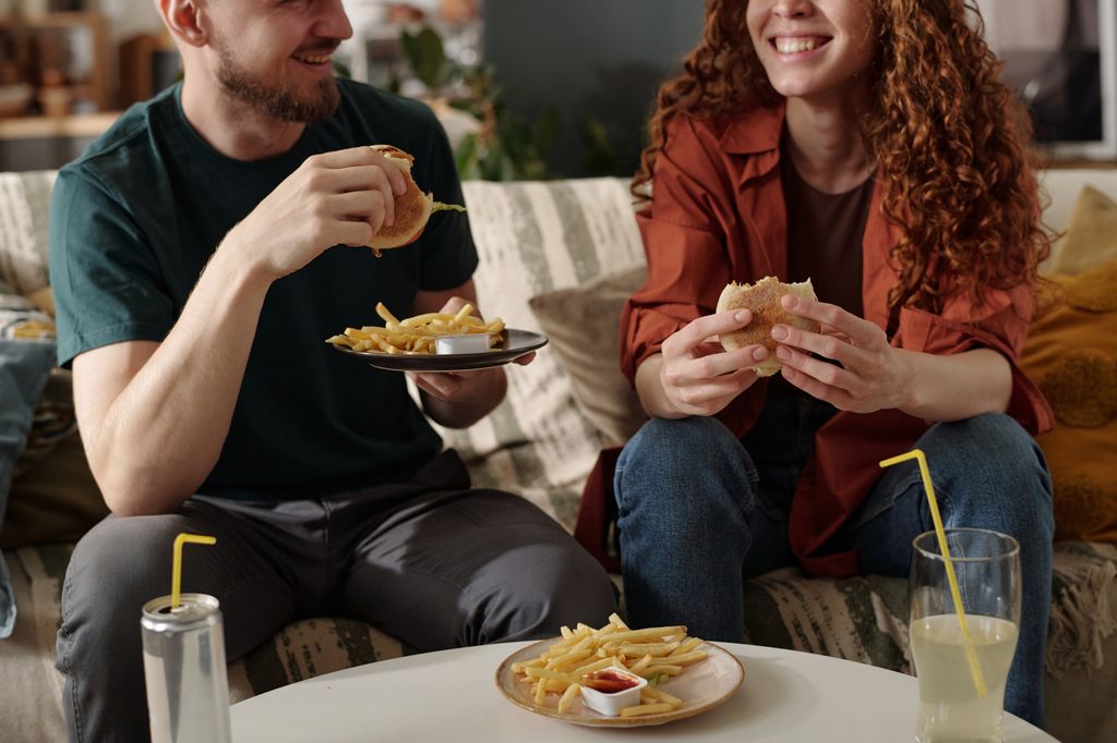 man and woman eating ultra-processed junk foods