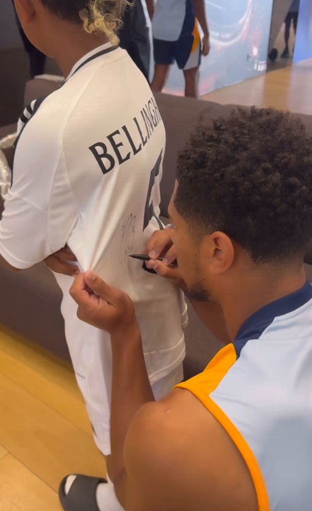 Jude Bellingham signs a footbal shirt for Kim's son Saint