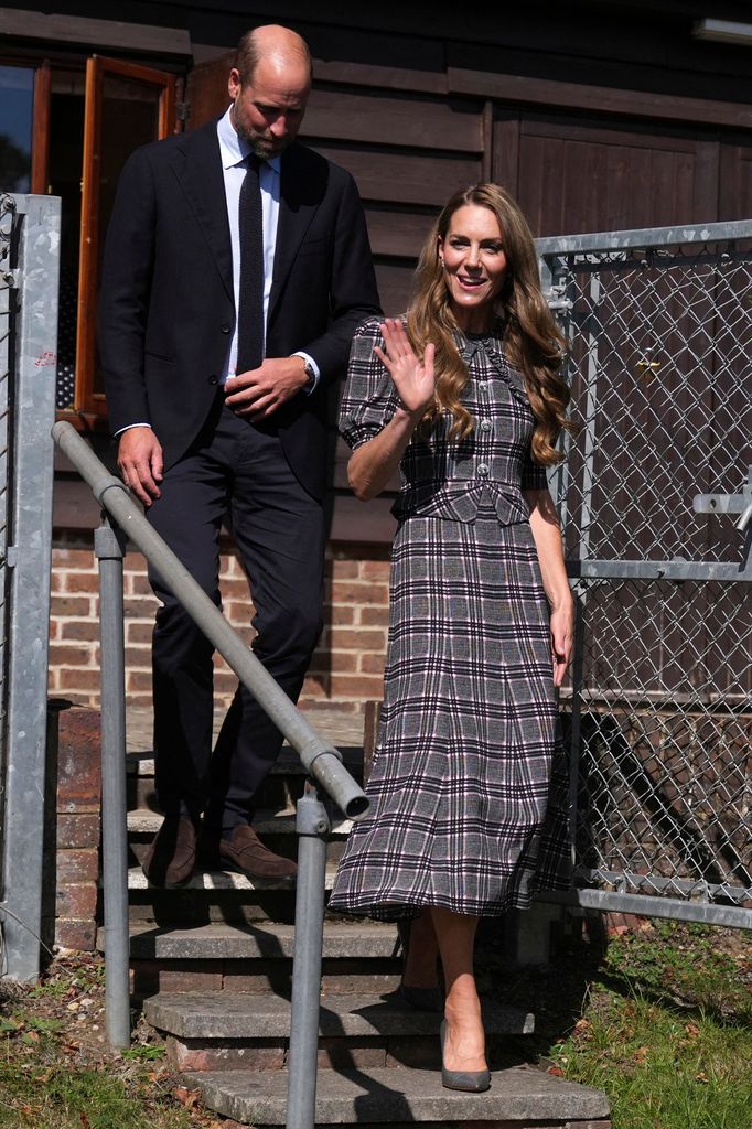 Catherine, Princess of Wales and William, Prince of Wales departing a visit to the National Federation of Women's Institute. Cathrine is wearing a set, a grey checked blazer and long skirt and William is wearing a black suit