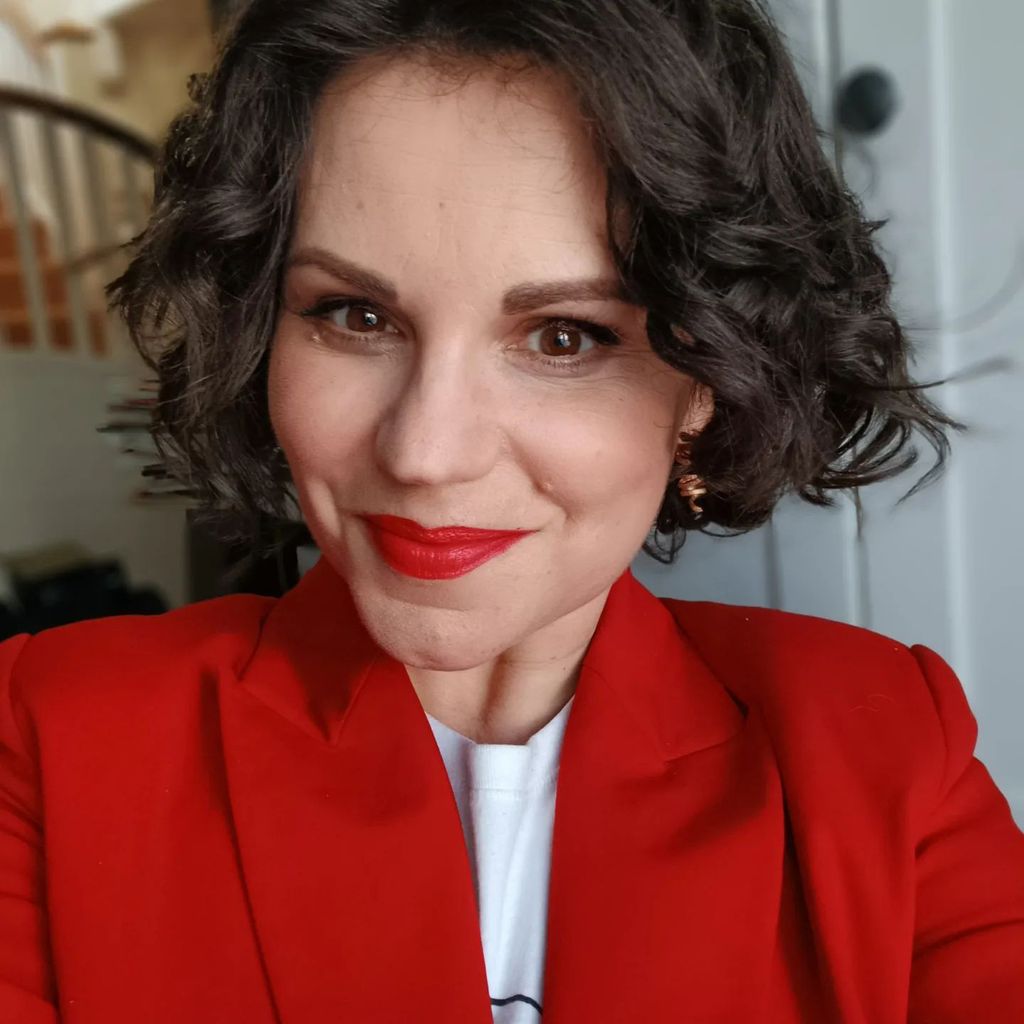 woman posing for a selfie with red lipstick and a red blazer