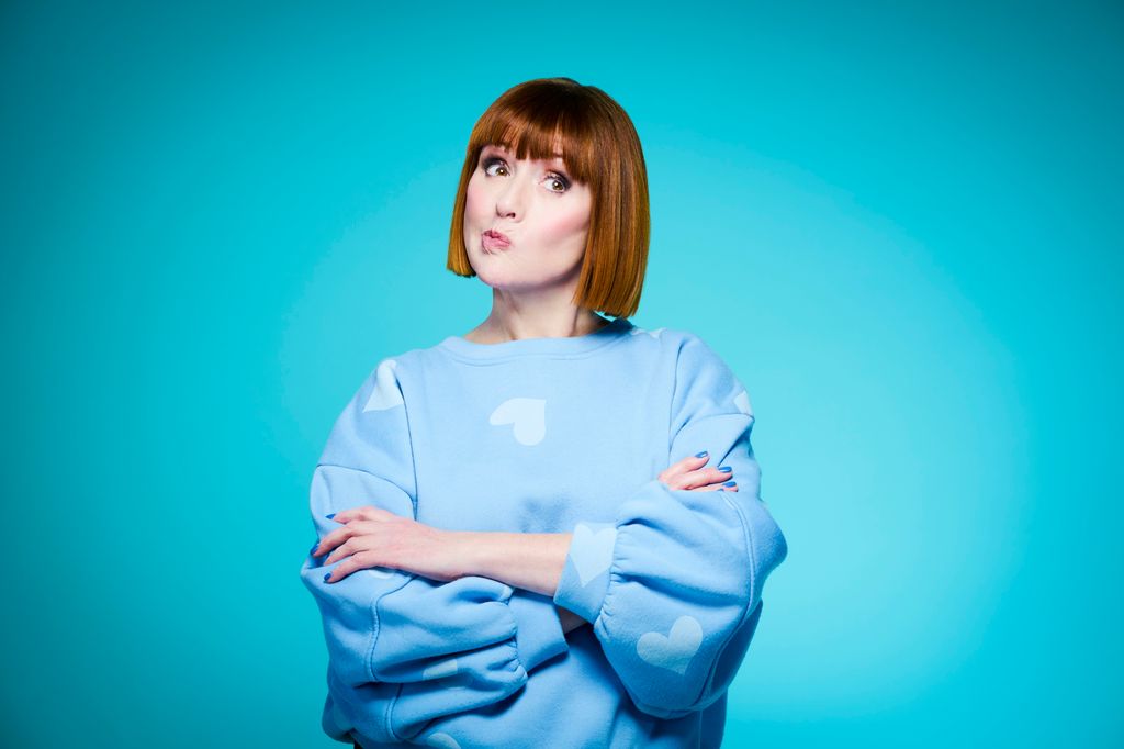 woman in a blue jumper pulling a face