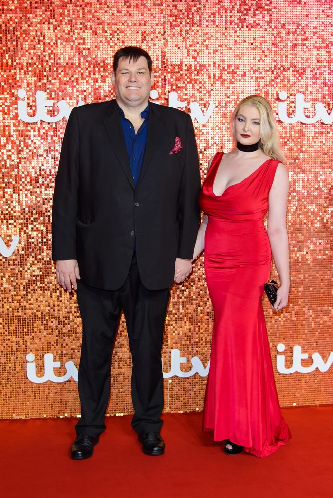 Mark Labbett in a black suit and Katie Labbett in a red dress