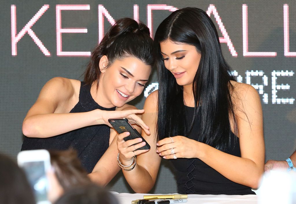 Kendall et Kylie Jenner regardant leur téléphone en 2015