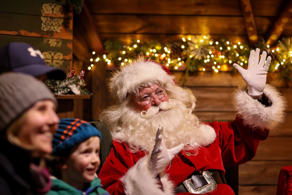 santa smiling and waving with families 