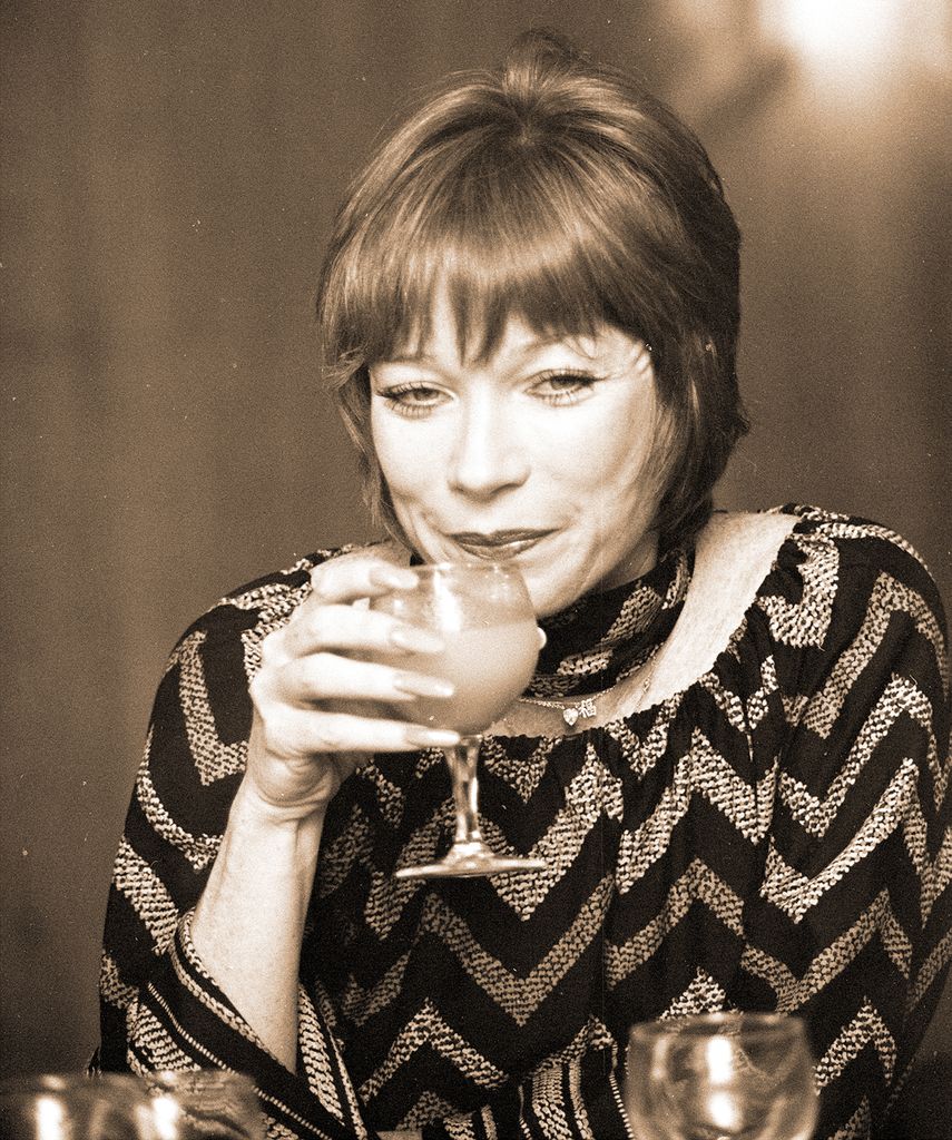 Shirley sipping on a cocktail