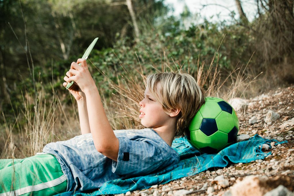A boy on his tablet outside