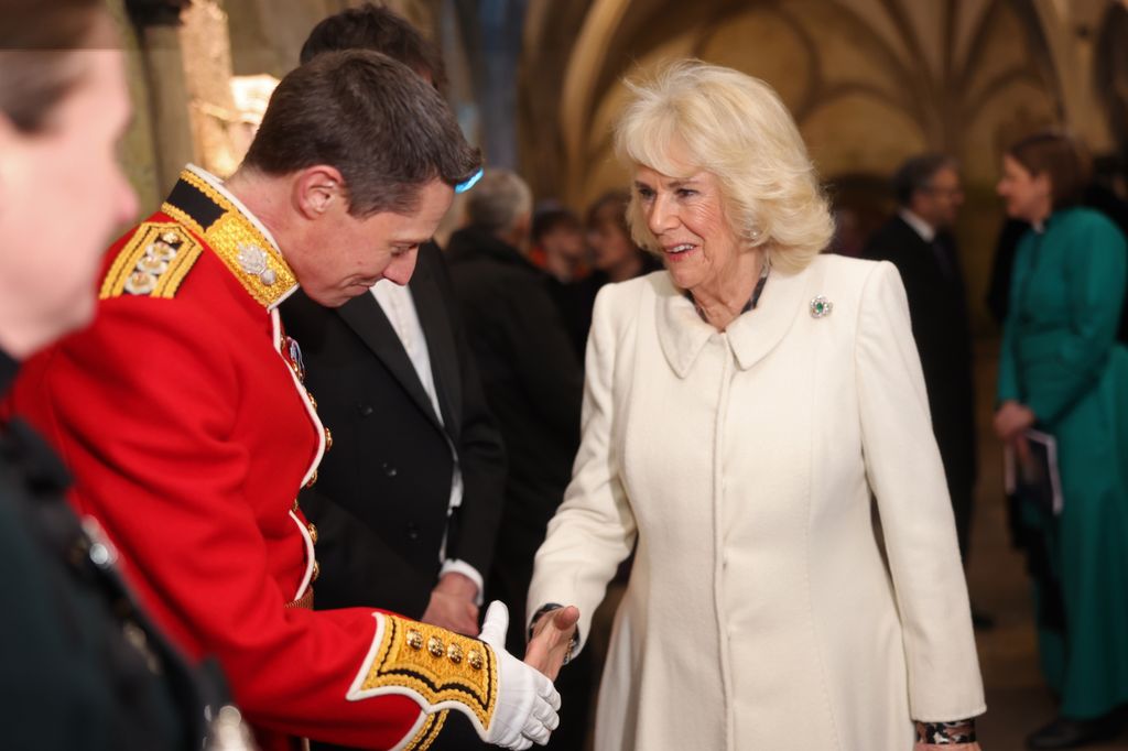  Queen Camilla shakes hands with a representative of the regimental charities du