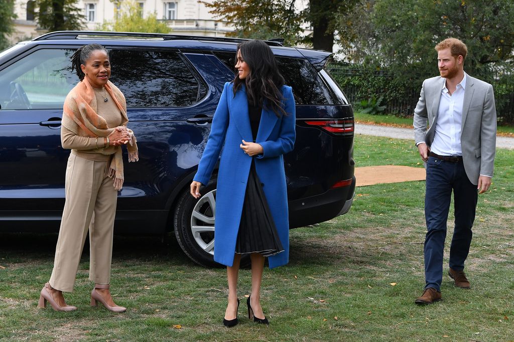Meghan, Duchess of Sussex (C) arrives with her mother Doria Ragland (L) and Prince Harry, Duke of Sussex to host an event to mark the launch of a cookbook with recipes from a group of women affected by the Grenfell Tower fire at Kensington Palace on Septe