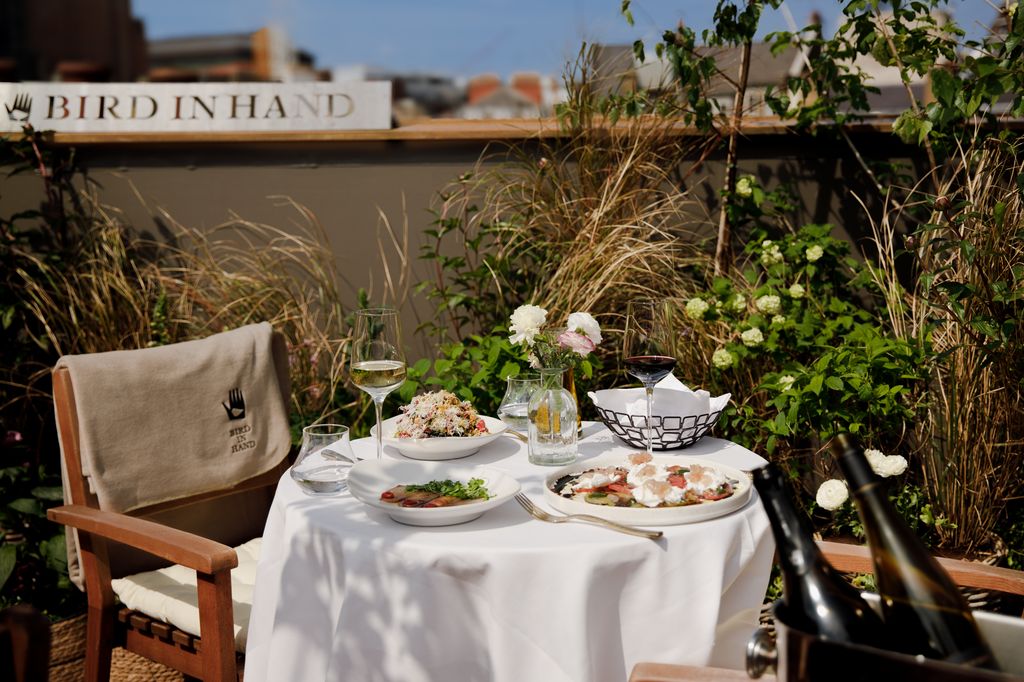 table with white tablecloth and food at rooftop bar