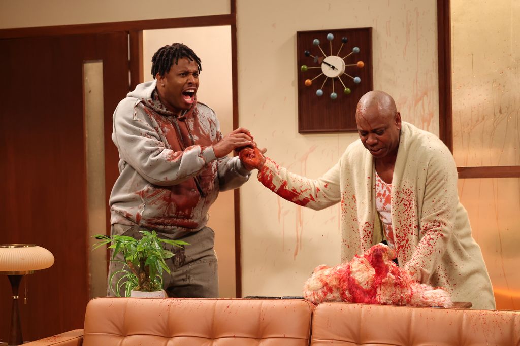 Devon Walker as Kevin and host Dave Chapelle as Reggie during the "Evacuation Alert" sketch on Saturday, January 18, 2025 -- (Photo by: Will Heath/NBC via Getty Images)