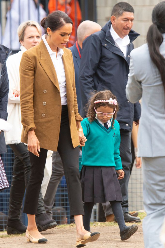 Meghan markle in camel blazer walking with child