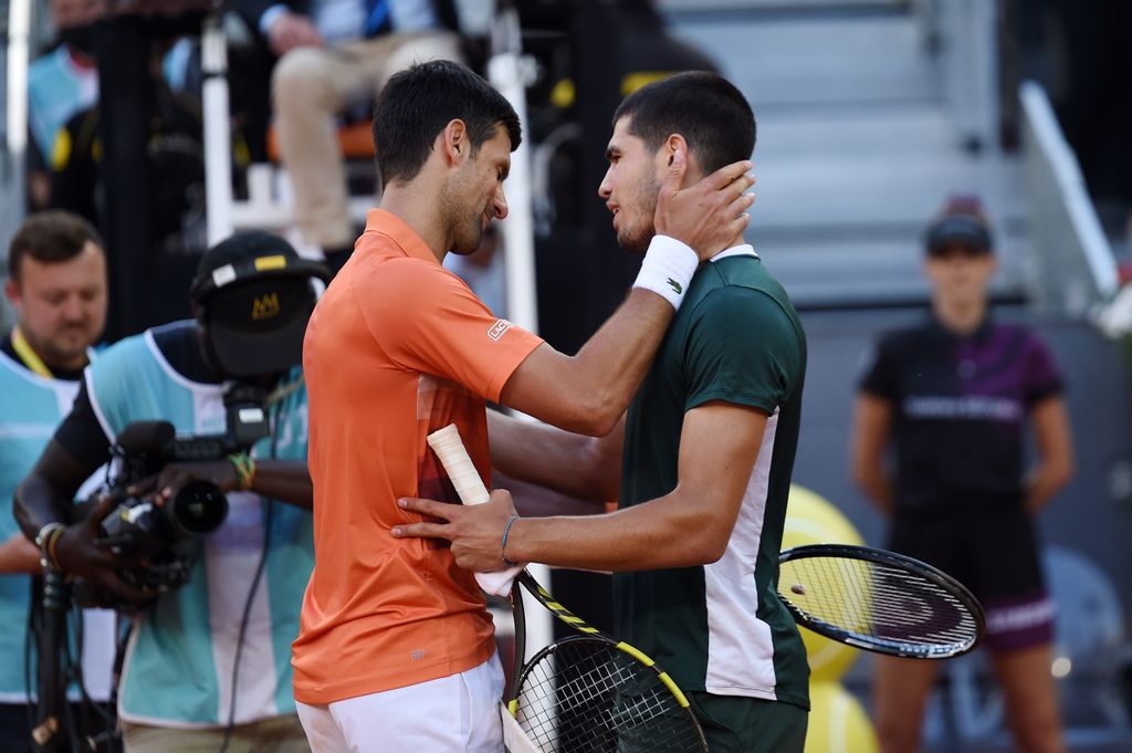 Novak Djokovic of Serbia and Carlos Alcaraz of Spain interact by the net after their Men's Singles Semi-finals match during day ten of Mutua Madrid Open at La Caja Magica on May 07, 2022 in Madrid, Spain