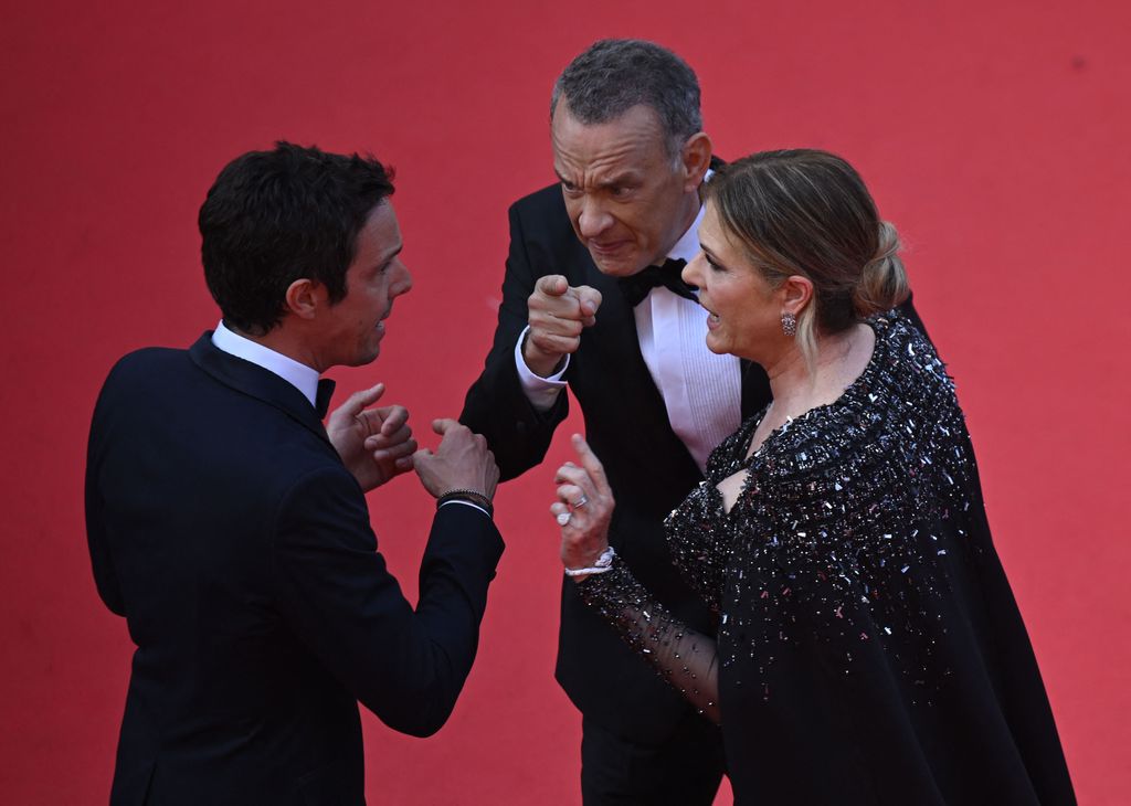 Tom Hanks and Rita Wilson seen in the midst of an intense discussion with a red carpet staffer at the 76th Cannes Film Festival