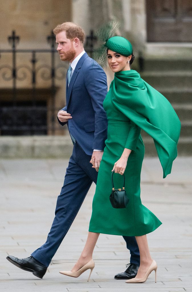 Meghan in green walking with harry