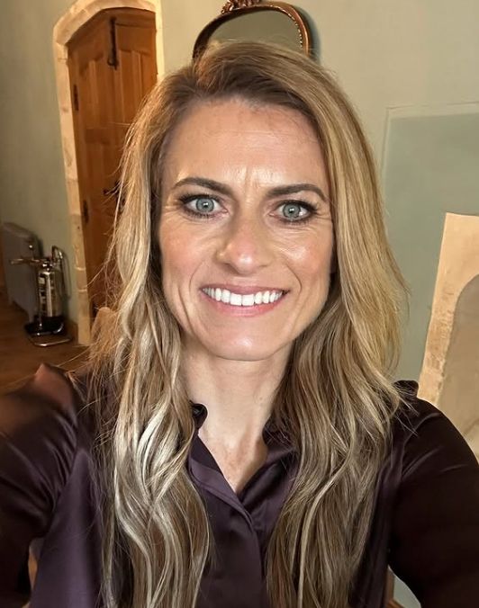 Karen Carney smiling from inside a house