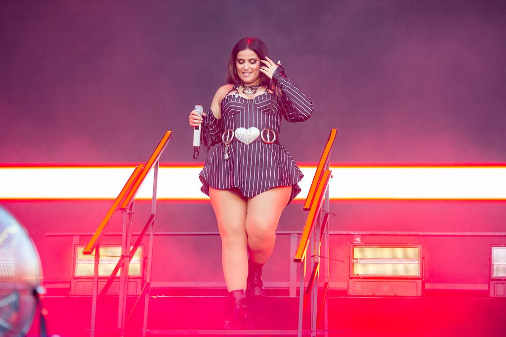 photo of nelly furtado in pinstripe mini dress on stage