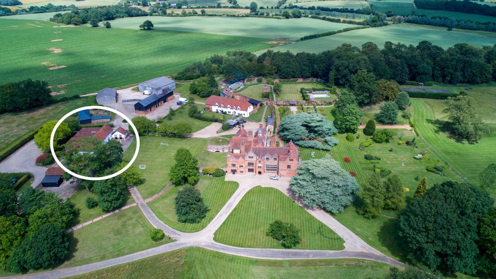 aerial view of manor house on land with stables circled