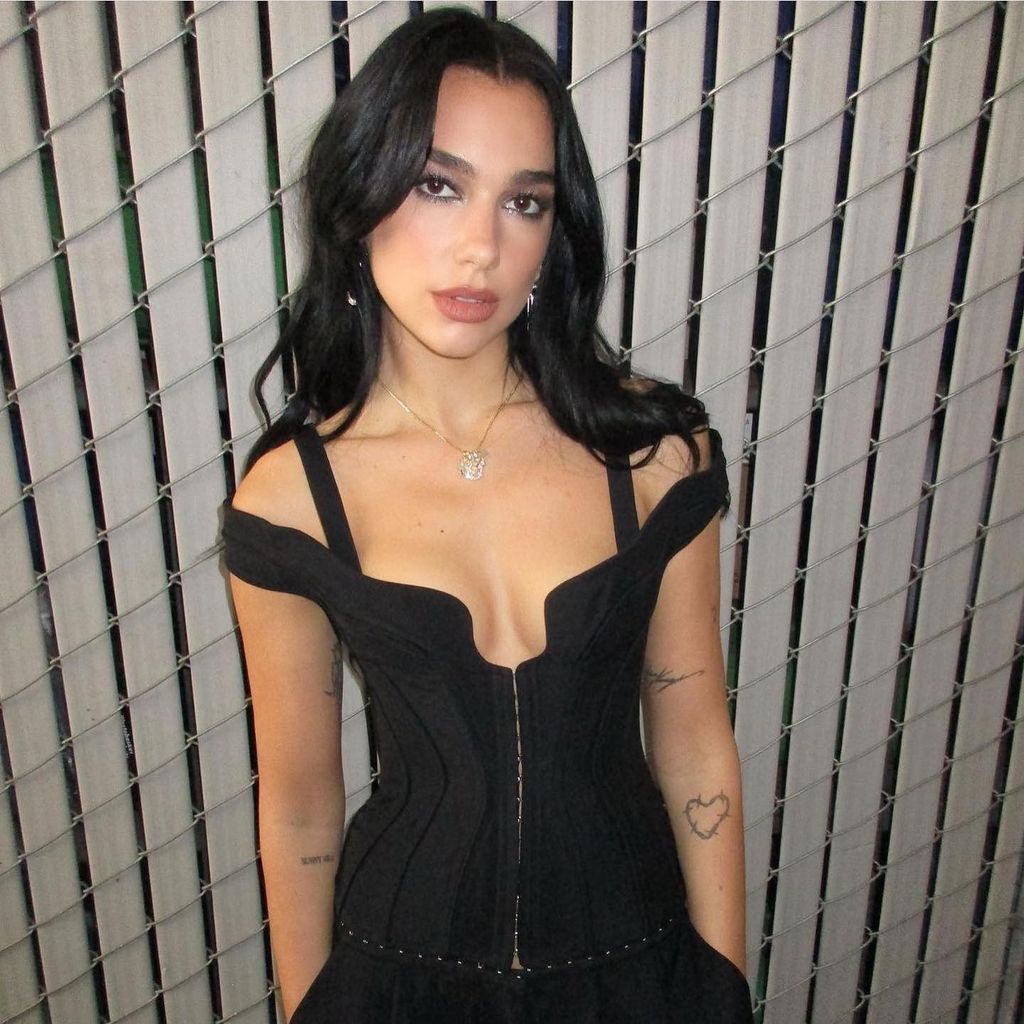 Dua Lipa with hair styled by Peter Lux - singer pictured in black dress