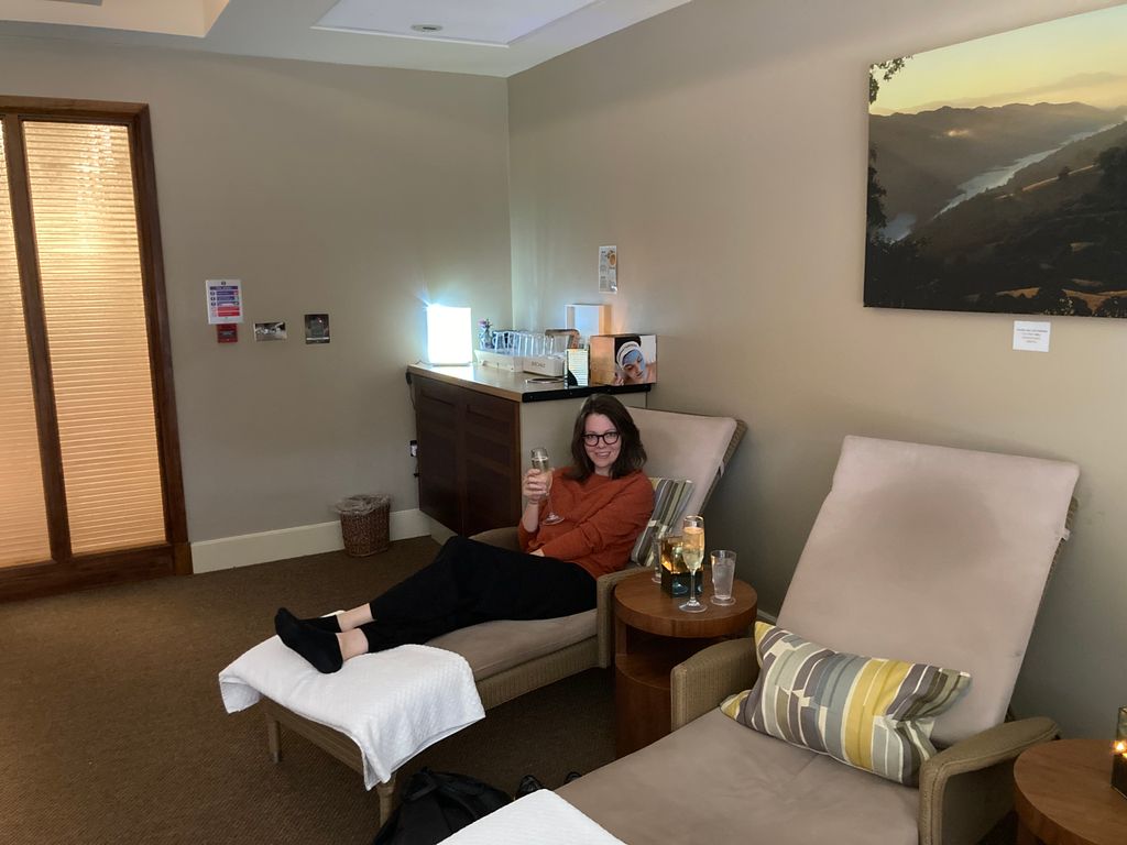 Woman holding a flute of champagne on an indoor lounger