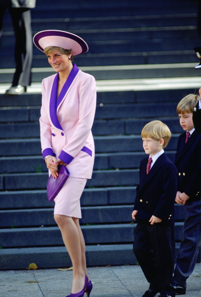 Princess Diana, accompanied by her sons, Prince Harry and Prince William to a special service for fire brigade veterans at St Paul's Cathedral. The Princess is wearing a pink and purple suit designed by Catherine Walker. 