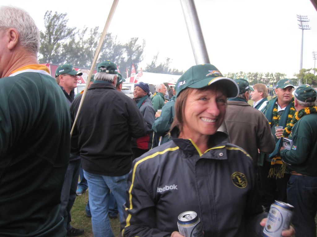 woman in a cap holding two drinks 