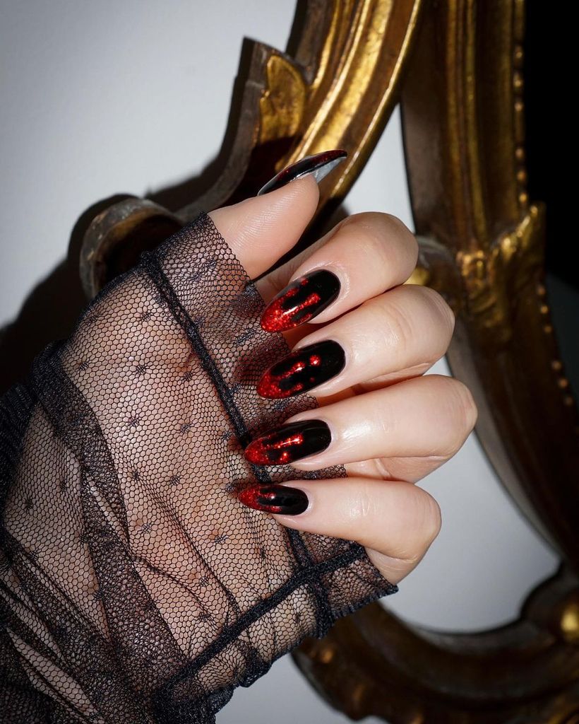 Dark and mysterious, this design features black nails with blood-red glitter dripping down for a vampy, dramatic look. 