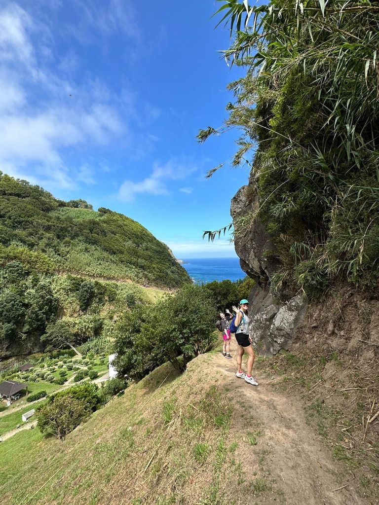 two women hiking in the azores with the sea behind them