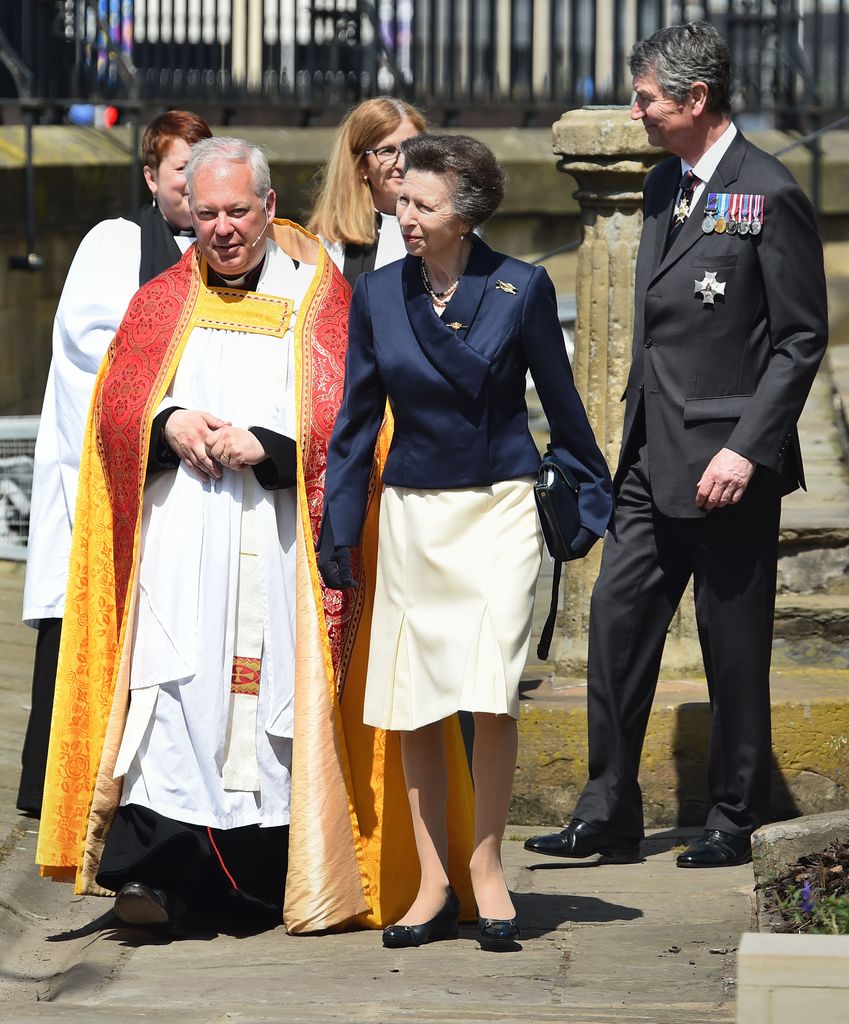 Princess Anne and Sir Timothy Laurence walking with rector from a church