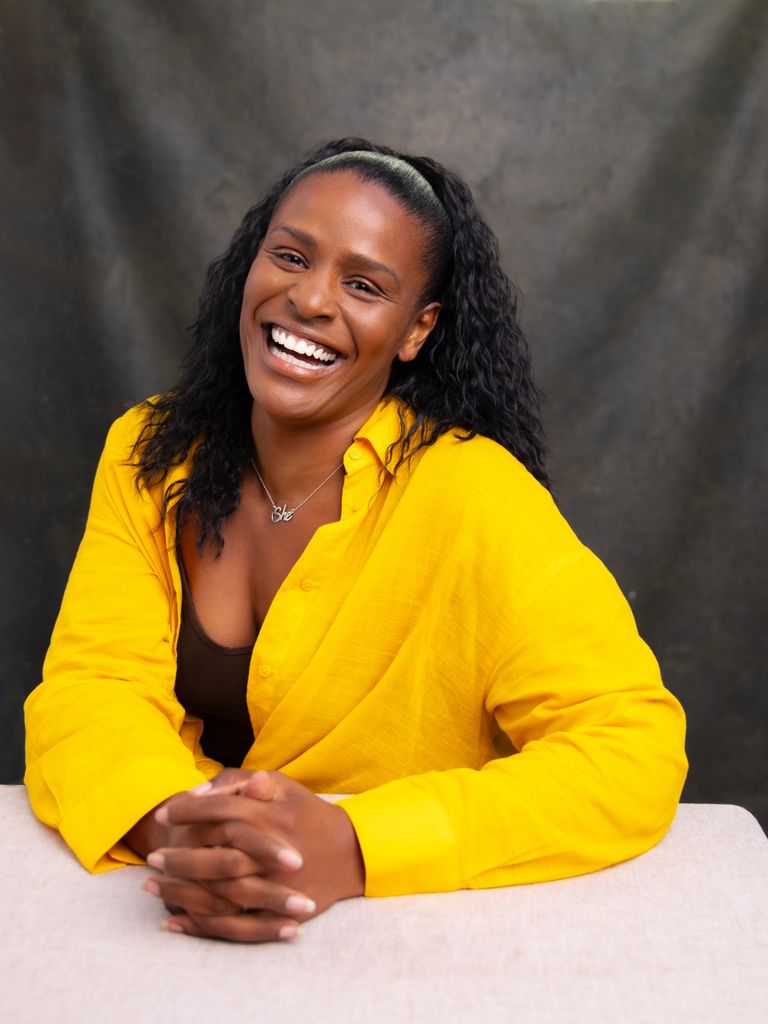Black woman smiling in a yellow shirt