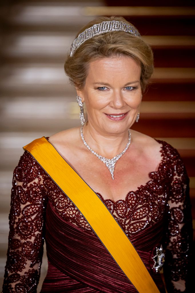 Queen Mathilde in burgundy dress and tiara
