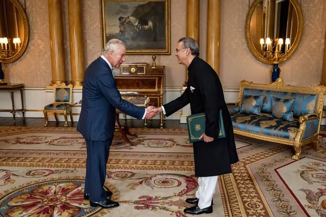 king charles shaking hands inside buckingham palace