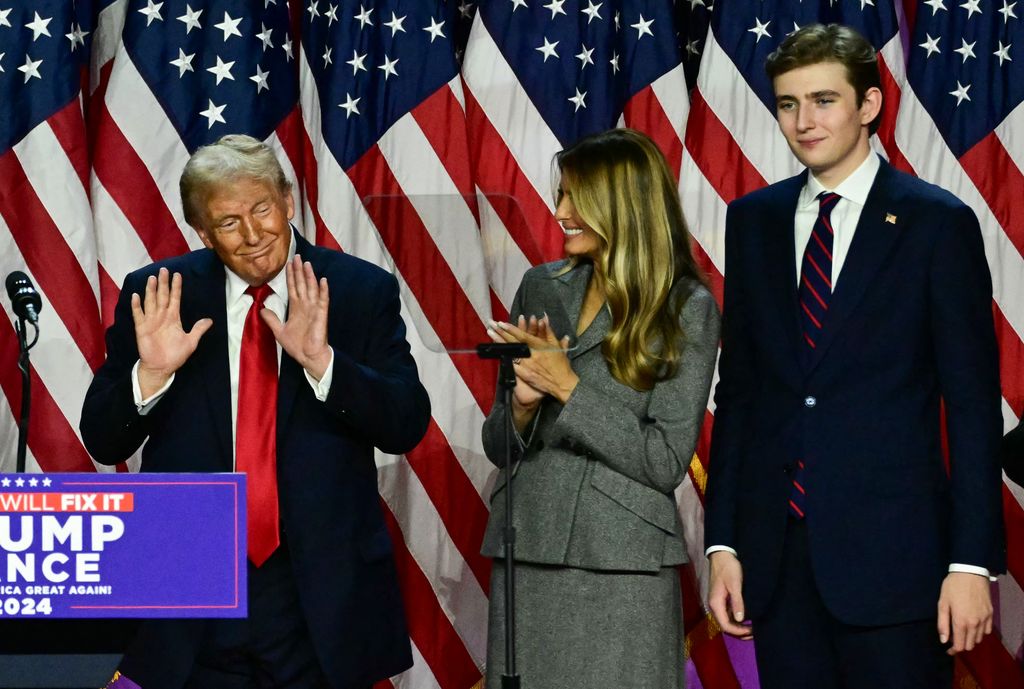 Former US President and Republican presidential candidate Donald Trump gestures, next to former US First Lady Melania Trump and their son Barron Trump during an election night event at the West Palm Beach Convention Center in West Palm Beach, Florida, early on November 6, 2024. (Photo by Jim WATSON / AFP) (Photo by JIM WATSON/AFP via Getty Images)