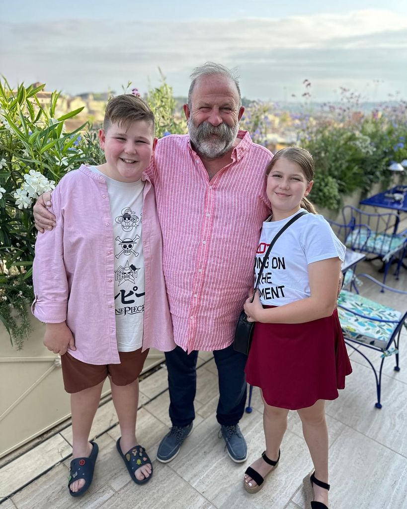 father and 2 kids posing for photo on holiday